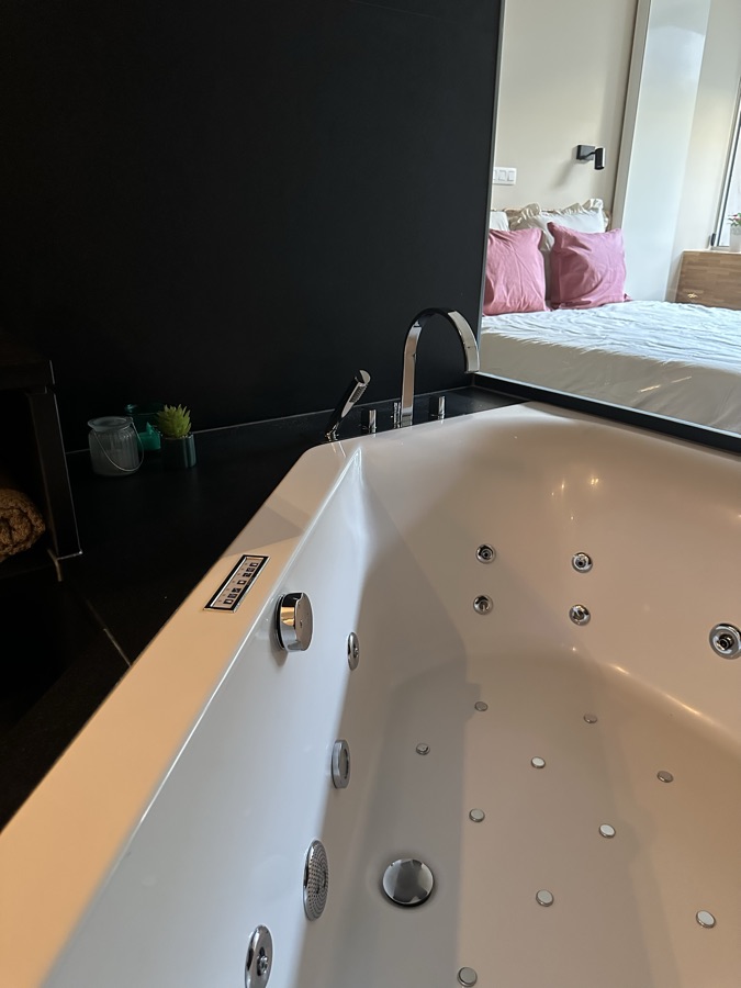 Whirlpoolbad met zicht op de aangrenzende slaapkamer