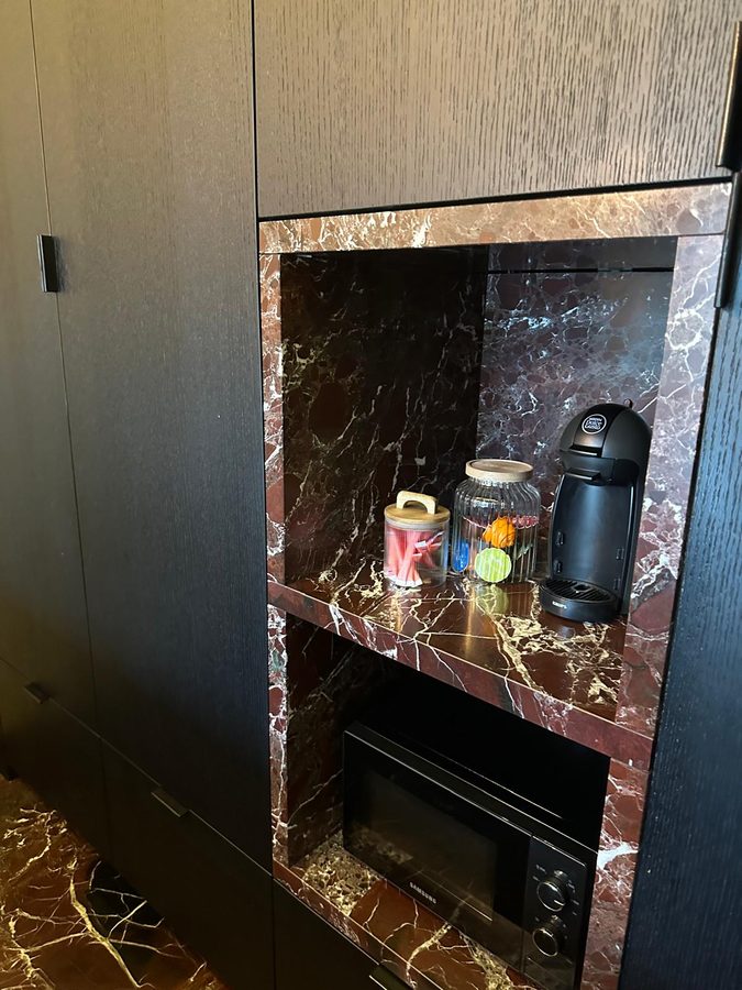 Koffiehoek met koffiezetapparaat, voorraadpotten en microgolfoven in de keukenkast