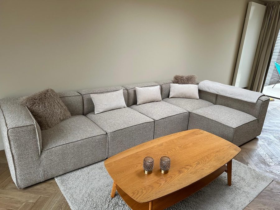 Modulaire hoekzetel met kussens en eiken salontafel op het visgraatparket