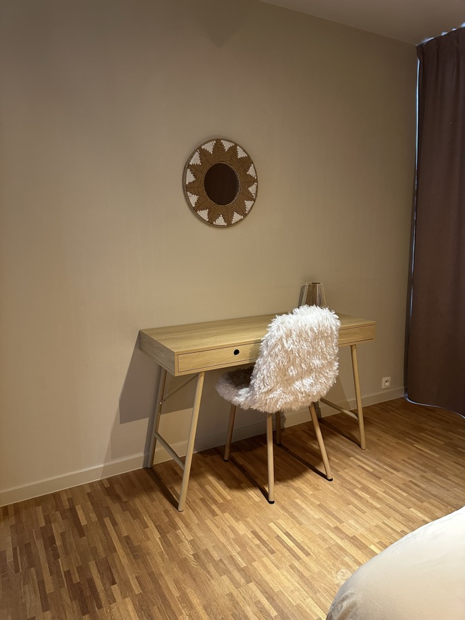 Houten bureau met vachtstoel en ronde wanddecoratie