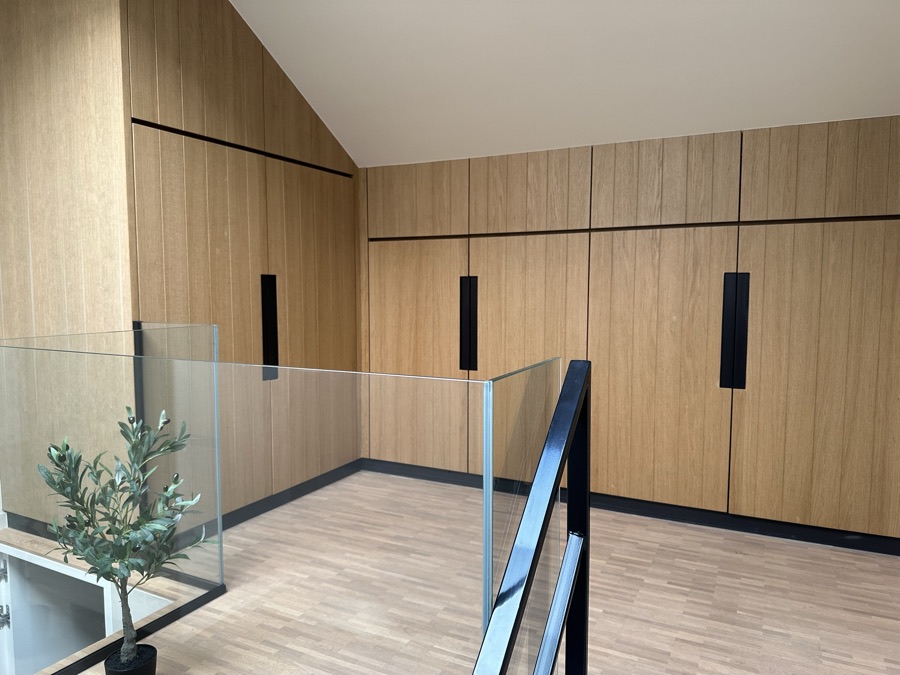 Overloop met eiken kastenwand en glazen balustrade