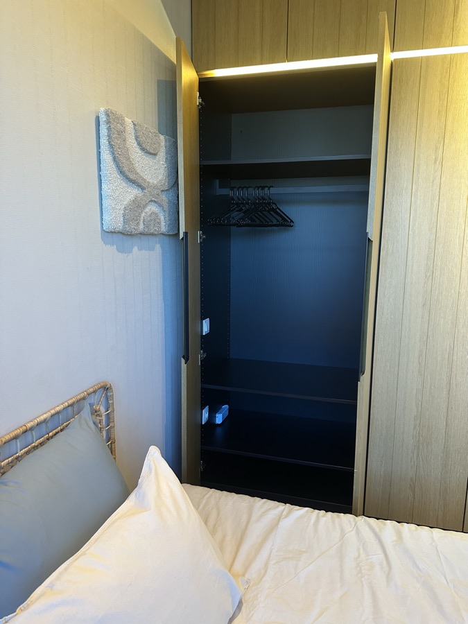 Open kleerkast in eik naast het bed