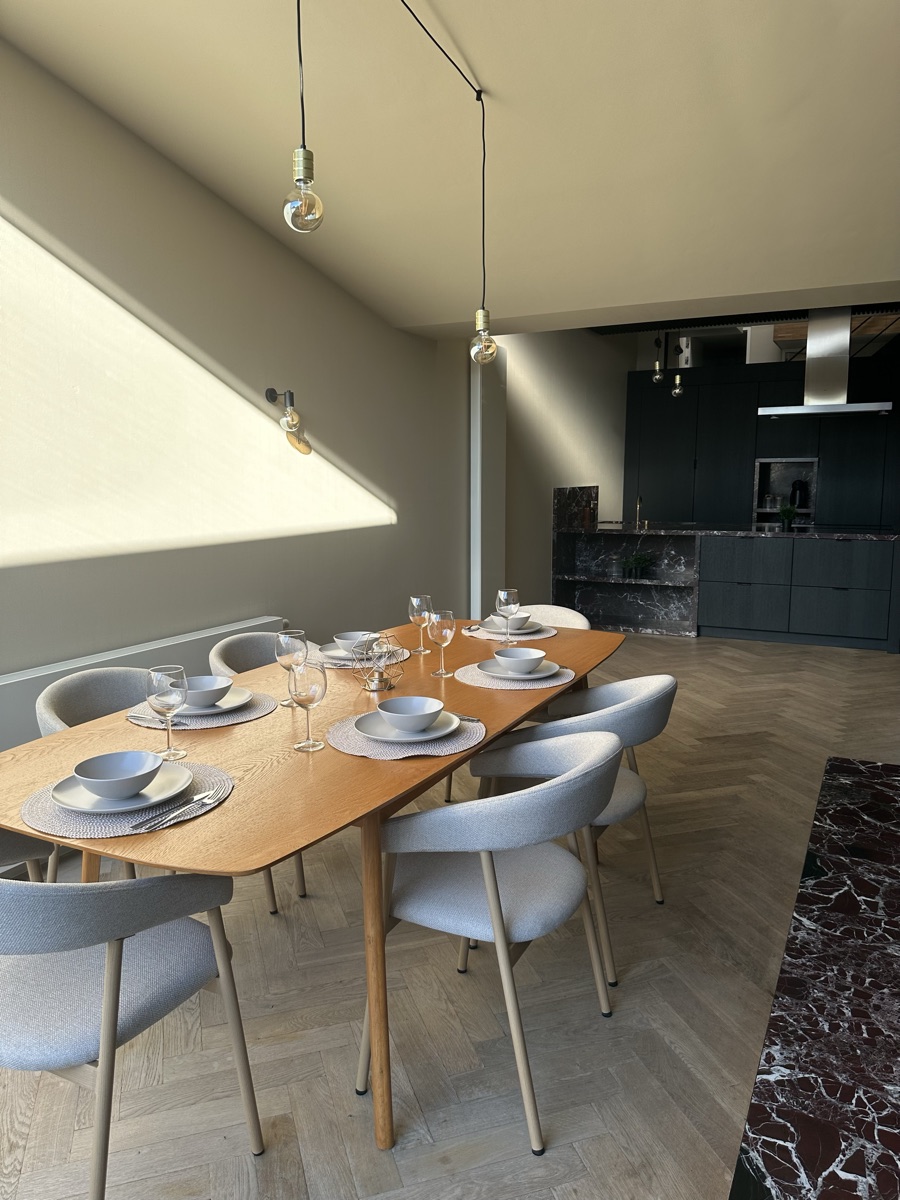 Gedekte eettafel met zicht op de open keuken in Het Demerhuys